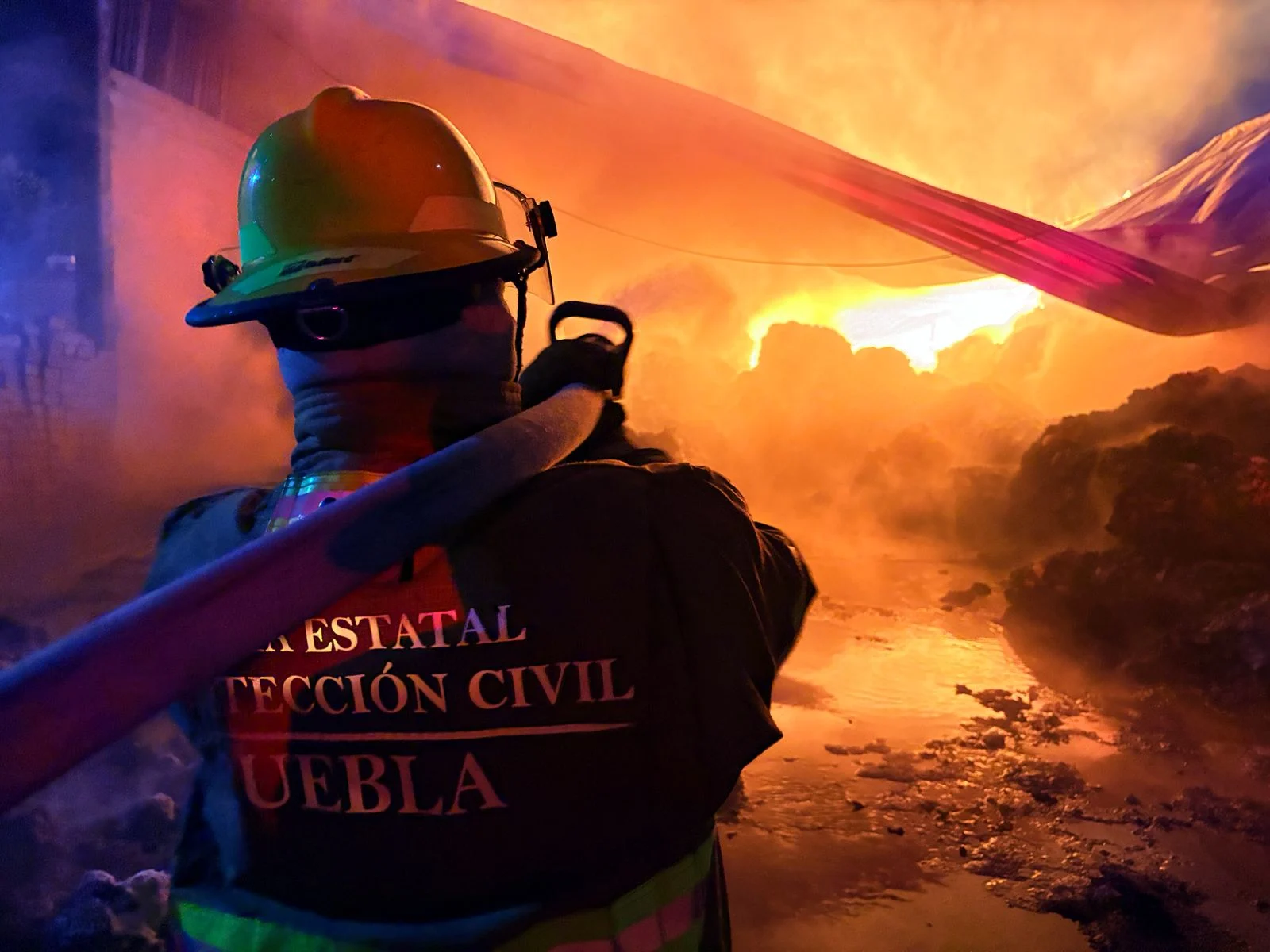 Elemento de Protección Civil Estatal Puebla combate incendio en bodega de material reciclable en Santiago de los Leones.